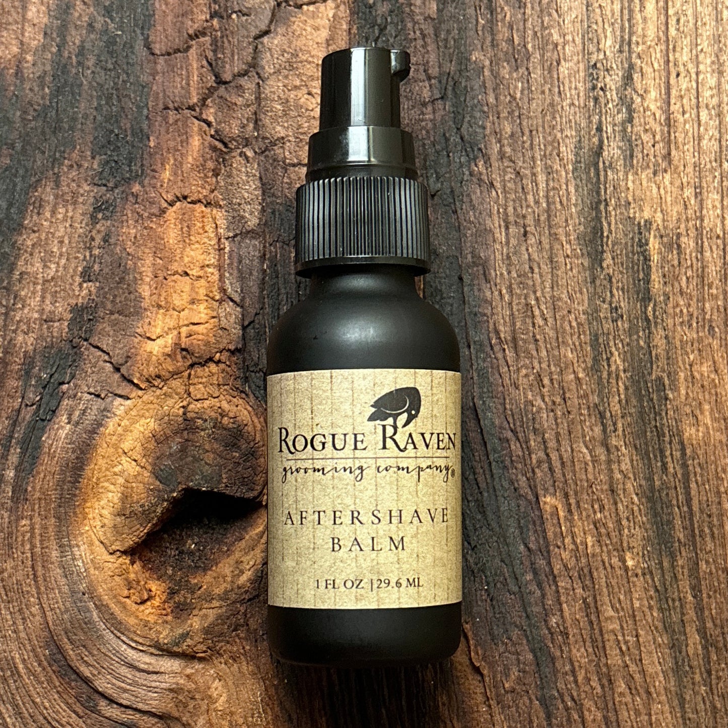 Bottle of Rogue Raven aftershave balm on a wooden surface