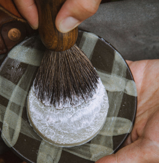 A premium men's wet shave set featuring a ceramic shave bowl, ebony-handled shave brush, and natural shave soap puck – handcrafted by Rogue Raven Grooming.
